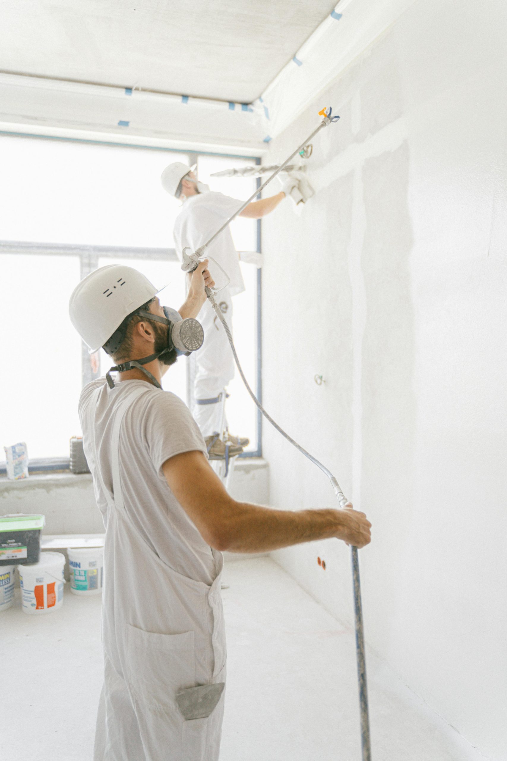 Painters paint spraying a wall